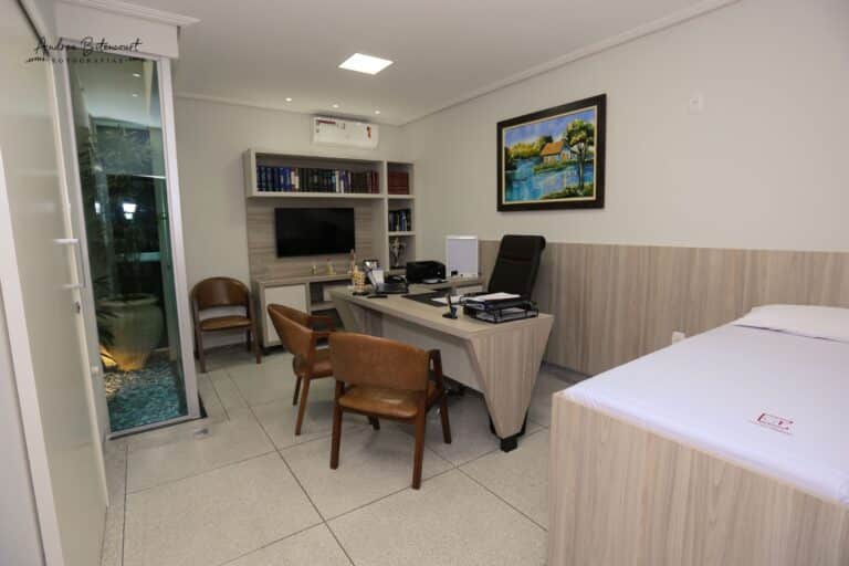 Consultório médico da Clínica Gattass Ferreira com mesa, computador e maca