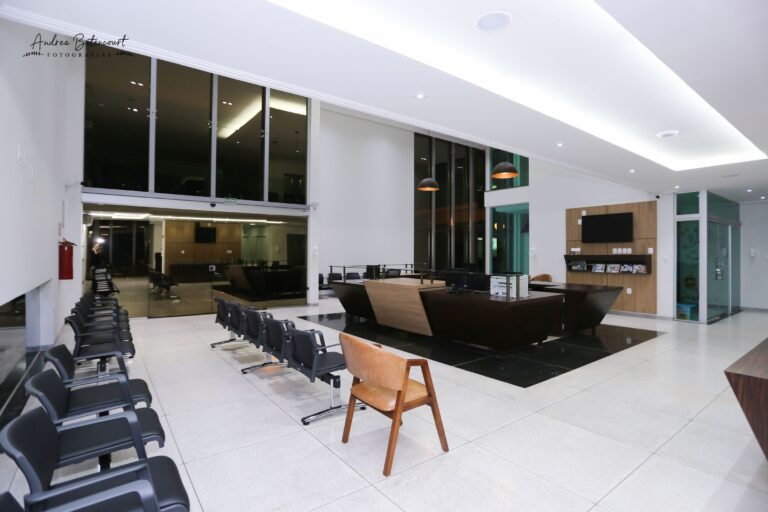 Sala de espera da Clínica Gattass Ferreira com poltronas e televisão