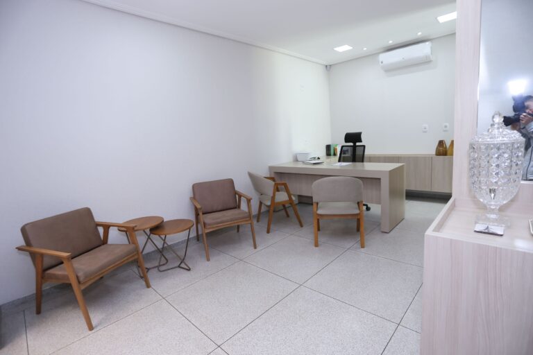 Consultório da Clínica Gattass Ferreira com mesa de atendimento e poltronas